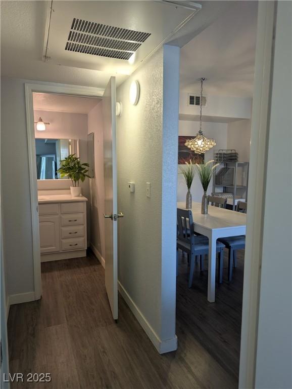 6650 W Warm Springs Rd Unit 2159, Las Vegas, NV 89118 - hallway with dark wood-type flooring, baseboards, and a chandelier
