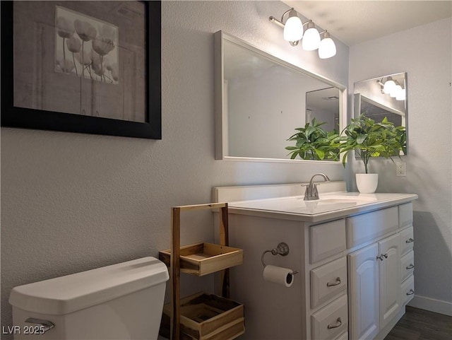 6650 W Warm Springs Rd Unit 2159, Las Vegas, NV 89118 - bathroom featuring toilet, vanity, wood finished floors, and baseboards