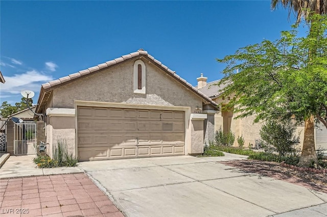 8242 Tribute Ln, Las Vegas, NV 89147 - view of front of house with driveway, a garage, stucco siding, a tiled roof, and a gate