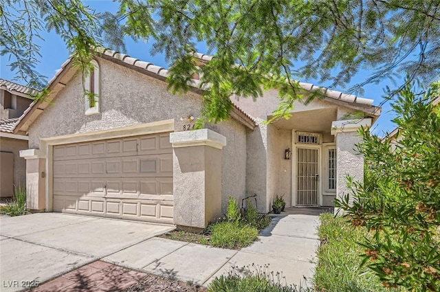 8242 Tribute Ln, Las Vegas, NV 89147 - view of front facade featuring a garage, a tiled roof, driveway, and stucco siding