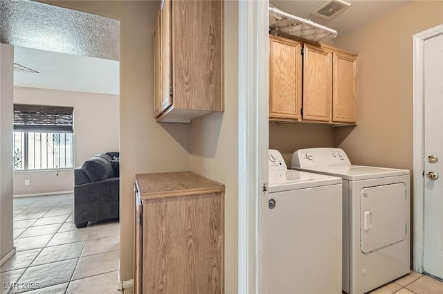 8242 Tribute Ln, Las Vegas, NV 89147 - washroom with separate washer and dryer, light tile patterned floors, and cabinet space