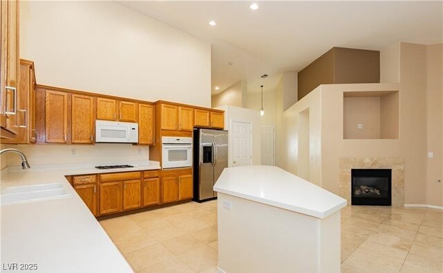 11204 Newbury Hills Ave, Las Vegas, NV 89138 - kitchen featuring white appliances, a sink, high vaulted ceiling, brown cabinets, and a center island