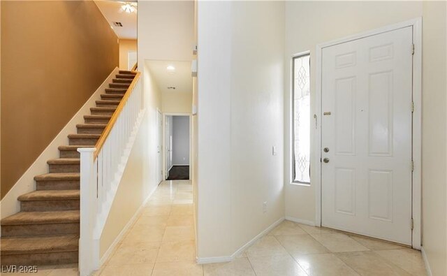 11204 Newbury Hills Ave, Las Vegas, NV 89138 - foyer entrance with light tile patterned floors, stairs, baseboards, and a towering ceiling