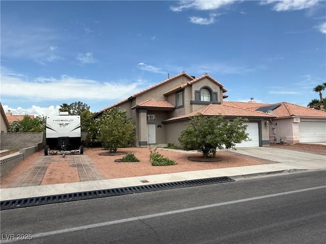 5517 Rock Creek Ln, Las Vegas, NV 89130 - mediterranean / spanish house featuring concrete driveway, stucco siding, a tiled roof, and a garage