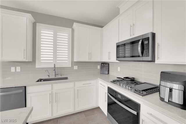 872 Pointe Arbor St, Henderson, NV 89011 - kitchen with appliances with stainless steel finishes, a sink, white cabinets, and tasteful backsplash