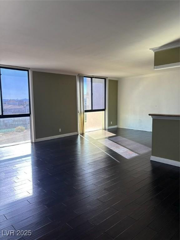 3930 University Center Dr Unit 702, Las Vegas, NV 89119 - unfurnished room featuring expansive windows, dark wood finished floors, and baseboards