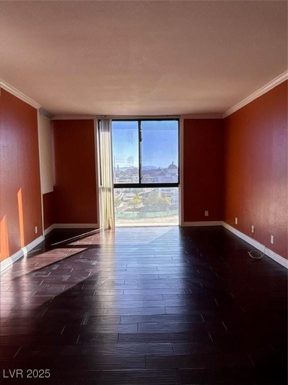 3930 University Center Dr Unit 702, Las Vegas, NV 89119 - spare room with baseboards, ornamental molding, wood finished floors, and floor to ceiling windows