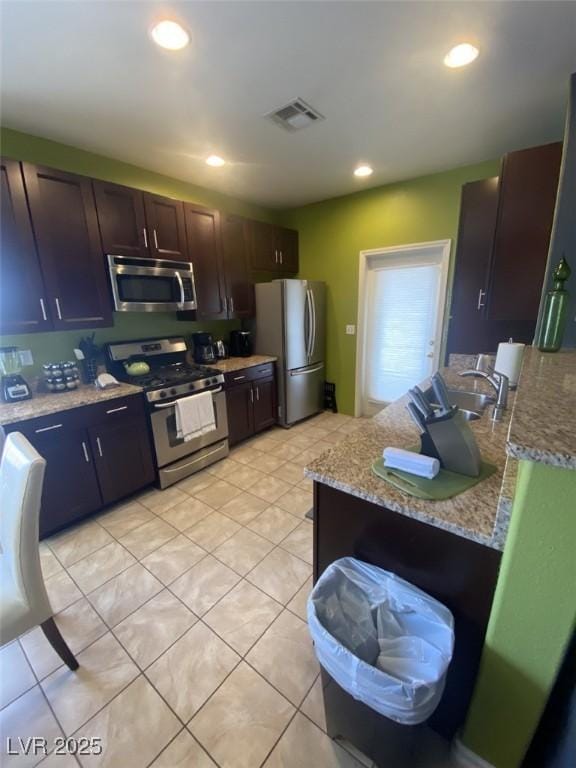 1511 Cardinal Peak Ln Unit 201, Las Vegas, NV 89144 - kitchen with stainless steel appliances, light tile patterned floors, a sink, recessed lighting, and dark brown cabinetry