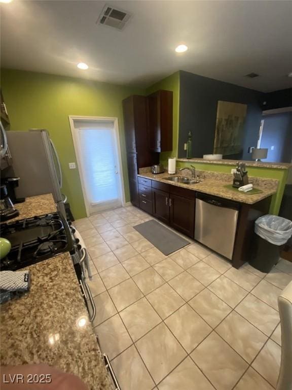 1511 Cardinal Peak Ln Unit 201, Las Vegas, NV 89144 - kitchen with stainless steel appliances, a sink, light tile patterned floors, light stone countertops, and dark brown cabinetry