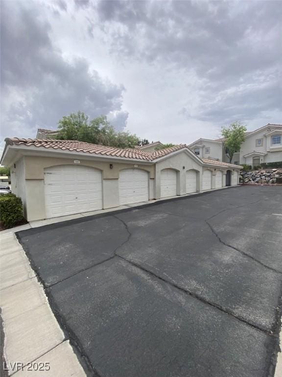 1511 Cardinal Peak Ln Unit 201, Las Vegas, NV 89144 - view of front facade featuring community garages, a tile roof, and stucco siding