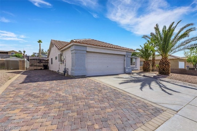 341 Waterwheel Falls Dr, Henderson, NV 89015 - view of front of property featuring concrete driveway, a gate, an attached garage, stucco siding, and a tile roof