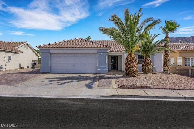 341 Waterwheel Falls Dr, Henderson, NV 89015 - mediterranean / spanish-style house featuring concrete driveway, stucco siding, an attached garage, and a tiled roof