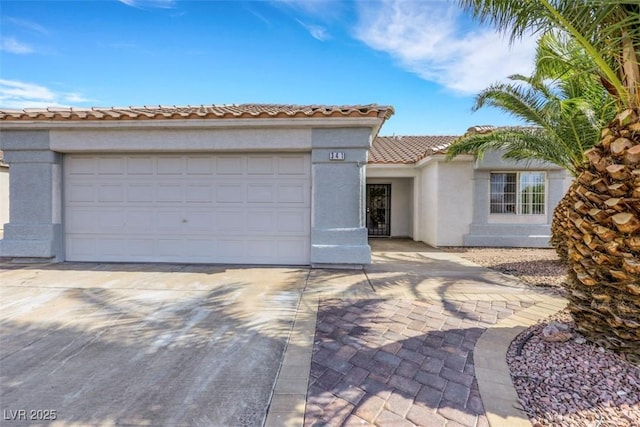 341 Waterwheel Falls Dr, Henderson, NV 89015 - view of front of home with a tile roof, stucco siding, driveway, and an attached garage