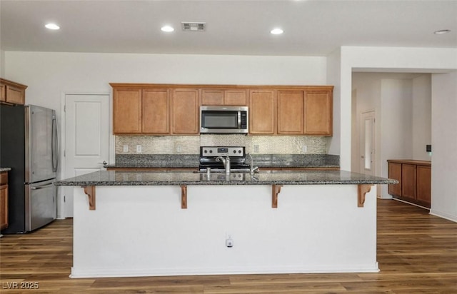 5235 E Ln Campana Dr, Pahrump, NV 89061 - kitchen featuring stainless steel appliances, a sink, backsplash, a kitchen bar, and recessed lighting