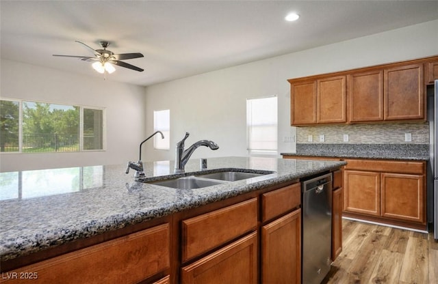 5235 E Ln Campana Dr, Pahrump, NV 89061 - kitchen with a sink, stainless steel dishwasher, dark stone counters, light wood-style flooring, and ceiling fan