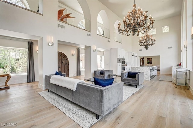 4162 Matterhorn Way, Las Vegas, NV 89124 - living room with light wood finished floors, a chandelier, a high ceiling, and baseboards