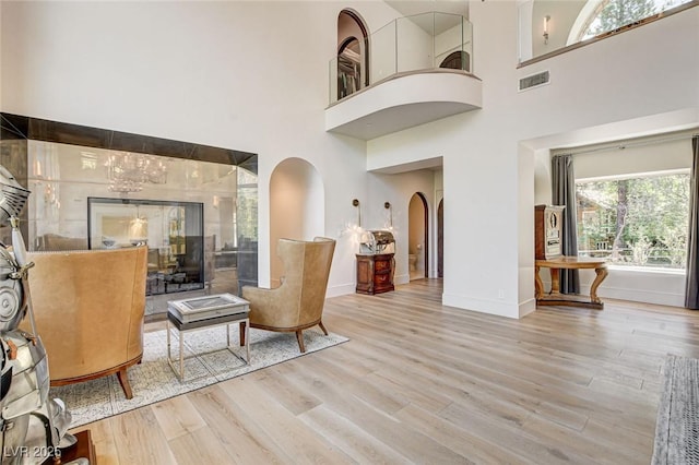 4162 Matterhorn Way, Las Vegas, NV 89124 - living room with arched walkways, a towering ceiling, wood finished floors, and baseboards