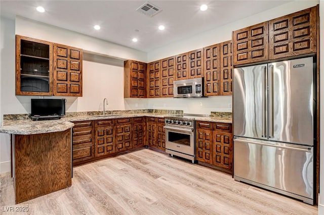 4162 Matterhorn Way, Las Vegas, NV 89124 - kitchen with premium appliances, a sink, light stone counters, light wood-style flooring, and recessed lighting
