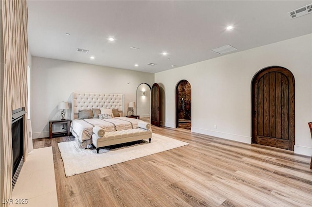 4162 Matterhorn Way, Las Vegas, NV 89124 - bedroom featuring arched walkways, light wood-style flooring, recessed lighting, baseboards, and a fireplace