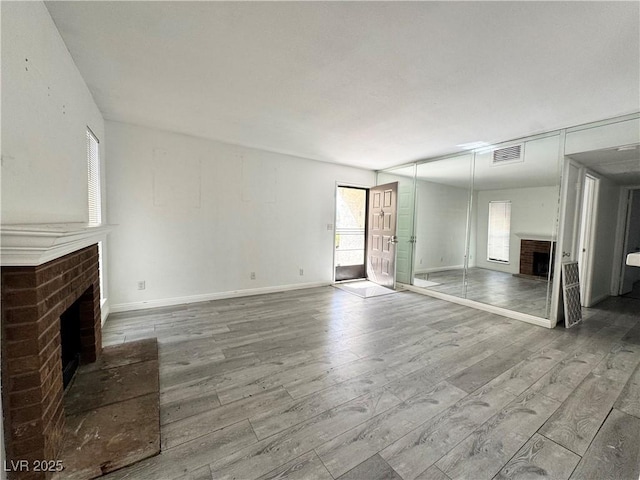 6137 W Oakey Blvd Unit A, Las Vegas, NV 89146 - unfurnished living room with a fireplace, wood finished floors, and baseboards
