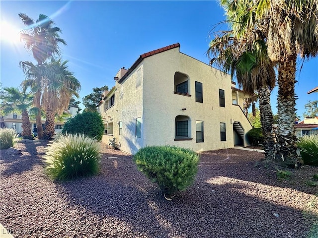 6137 W Oakey Blvd Unit A, Las Vegas, NV 89146 - view of property exterior featuring stucco siding, stairway, and a tile roof