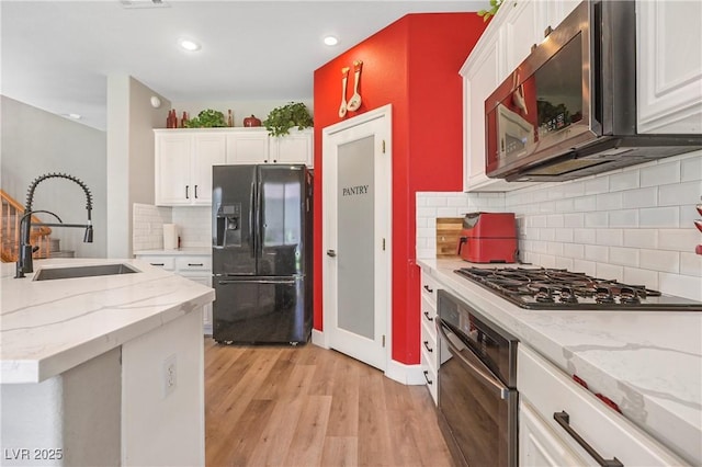 7821 Red Leaf Dr, Las Vegas, NV 89131 - kitchen featuring appliances with stainless steel finishes, light wood-type flooring, white cabinets, backsplash, and recessed lighting