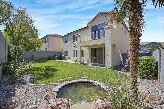 7821 Red Leaf Dr, Las Vegas, NV 89131 - rear view of house featuring a balcony, stucco siding, a fenced backyard, and a small pond