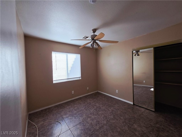 4704 Wild Oak Way N, Las Vegas, NV 89031 - unfurnished bedroom with a closet, a ceiling fan, tile patterned flooring, and a textured ceiling