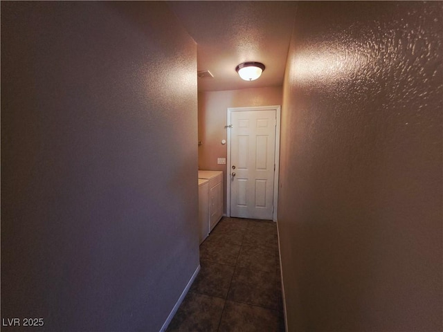 4704 Wild Oak Way N, Las Vegas, NV 89031 - hallway with washing machine and dryer, dark tile patterned floors, a textured wall, and a textured ceiling