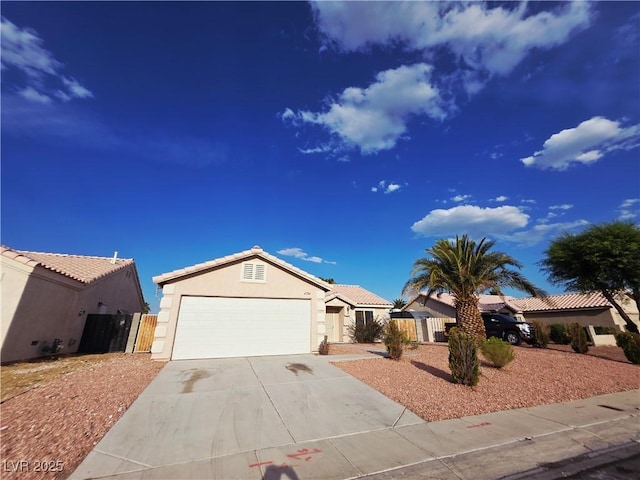 4704 Wild Oak Way N, Las Vegas, NV 89031 - ranch-style house featuring an attached garage, driveway, stucco siding, and a gate