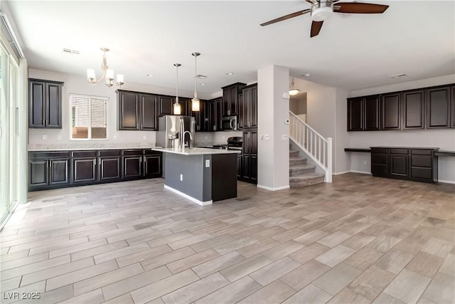 7345 Chesapeake Cove St, Las Vegas, NV 89166 - kitchen featuring stainless steel appliances, a ceiling fan, light countertops, a chandelier, and a center island with sink
