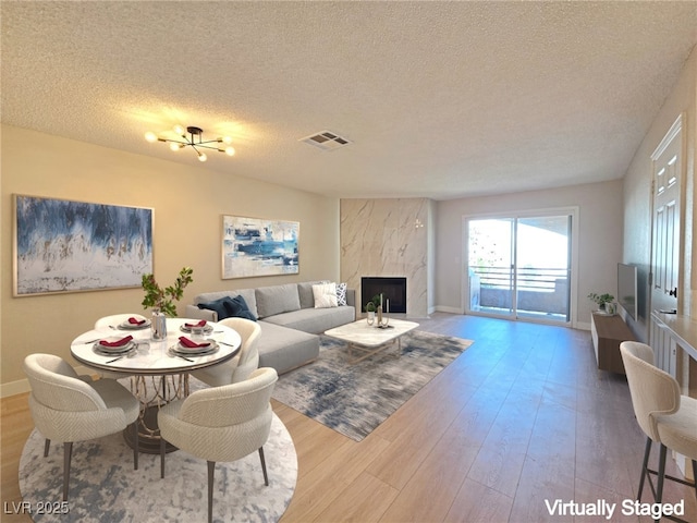 6853 Tamarus St Unit 202, Las Vegas, NV 89119 - living area featuring a textured ceiling, wood finished floors, baseboards, and a high end fireplace