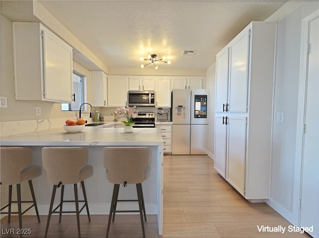 6853 Tamarus St Unit 202, Las Vegas, NV 89119 - kitchen featuring appliances with stainless steel finishes, a sink, a peninsula, and a breakfast bar area