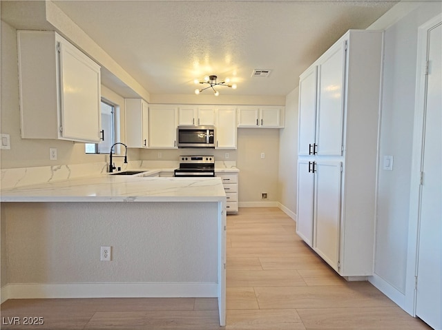 6853 Tamarus St Unit 202, Las Vegas, NV 89119 - kitchen with stainless steel appliances, a sink, a peninsula, baseboards, and white cabinets