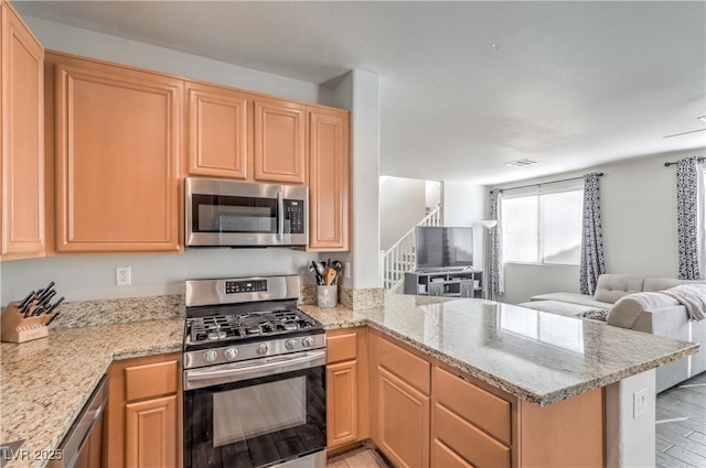5232 Pendergrass St, North Las Vegas, NV 89081 - kitchen with appliances with stainless steel finishes, open floor plan, a peninsula, light brown cabinets, and light stone counters