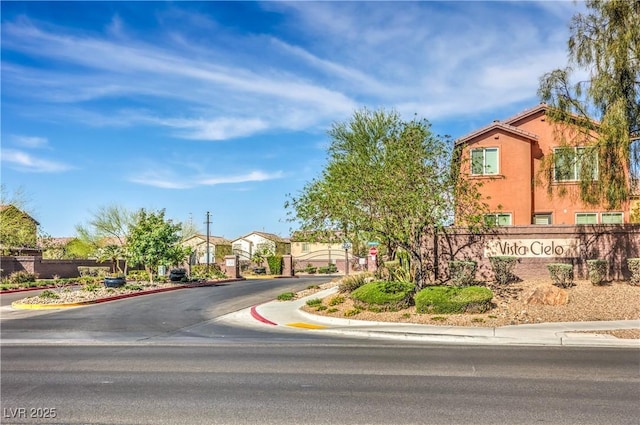 5232 Pendergrass St, North Las Vegas, NV 89081 - view of asphalt street with curbs, sidewalks, a gated entry, and a residential view