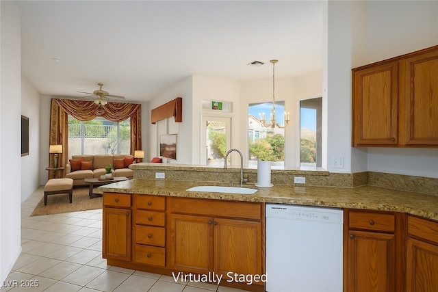 10628 Mission Lakes Ave, Las Vegas, NV 89134 - kitchen with white dishwasher, a sink, brown cabinetry, a chandelier, and light tile patterned floors