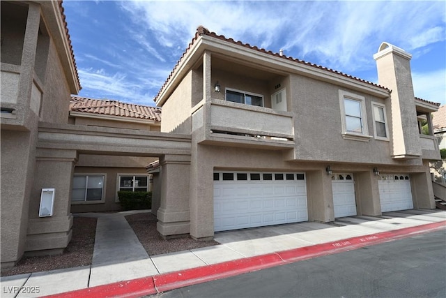 5125 W Reno Ave Unit 1059, Las Vegas, NV 89118 - townhome / multi-family property featuring stucco siding, a tile roof, and an attached garage