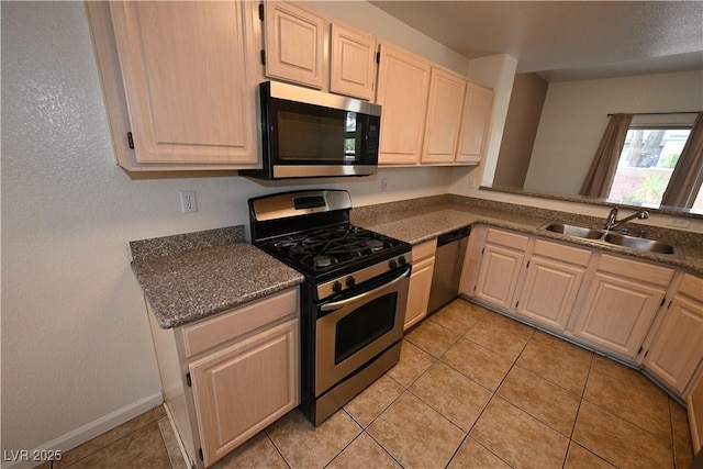 5125 W Reno Ave Unit 1059, Las Vegas, NV 89118 - kitchen with stainless steel appliances, a sink, light tile patterned flooring, and light brown cabinets