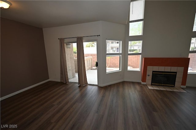 5125 W Reno Ave Unit 1059, Las Vegas, NV 89118 - unfurnished living room featuring dark wood finished floors, baseboards, and a tiled fireplace