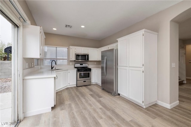 7836 Pinnochio Ave, Las Vegas, NV 89131 - kitchen with appliances with stainless steel finishes, light wood-type flooring, a sink, light countertops, and white cabinets