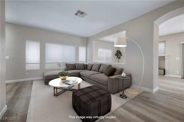7836 Pinnochio Ave, Las Vegas, NV 89131 - living room featuring arched walkways, wood finished floors, and baseboards