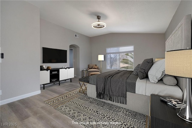 7836 Pinnochio Ave, Las Vegas, NV 89131 - bedroom featuring arched walkways, vaulted ceiling, wood finished floors, and baseboards