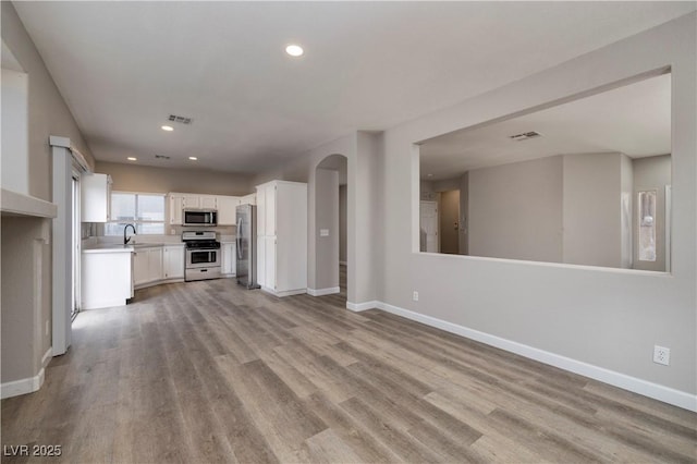 7836 Pinnochio Ave, Las Vegas, NV 89131 - unfurnished living room with a sink, light wood-type flooring, baseboards, and recessed lighting