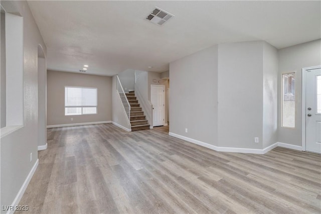 7836 Pinnochio Ave, Las Vegas, NV 89131 - unfurnished living room with light wood-style flooring, stairs, baseboards, arched walkways, and recessed lighting