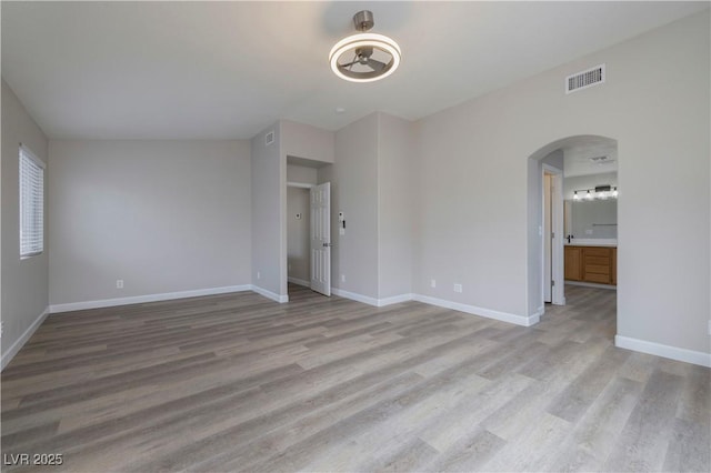 7836 Pinnochio Ave, Las Vegas, NV 89131 - empty room featuring light wood finished floors, arched walkways, and baseboards