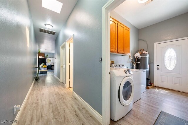 3360 National Ave, Pahrump, NV 89048 - washroom featuring cabinet space, washer and dryer, light wood-type flooring, a skylight, and baseboards