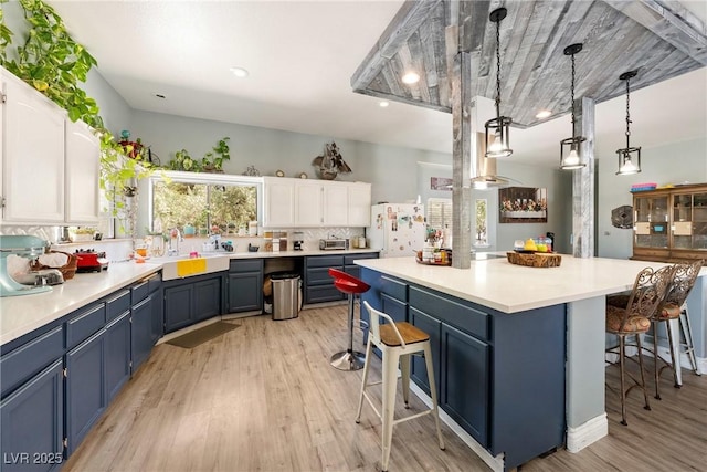 3360 National Ave, Pahrump, NV 89048 - kitchen featuring freestanding refrigerator, a breakfast bar, and blue cabinetry