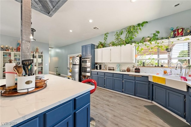 3360 National Ave, Pahrump, NV 89048 - kitchen featuring blue cabinets, a sink, stainless steel appliances, tasteful backsplash, and white cabinets