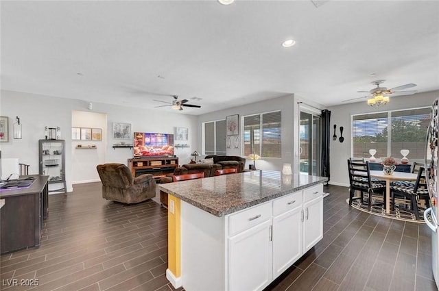 1120 Via Della Curia, Henderson, NV 89011 - kitchen with ceiling fan, wood tiled floors, white cabinets, and recessed lighting